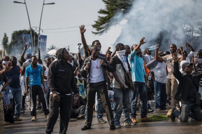 Supporters of Gabonese opposition leader Jean Ping face security forces (unseen) blocking the demonstration trying to reach the electoral commission in Libreville on August 31.